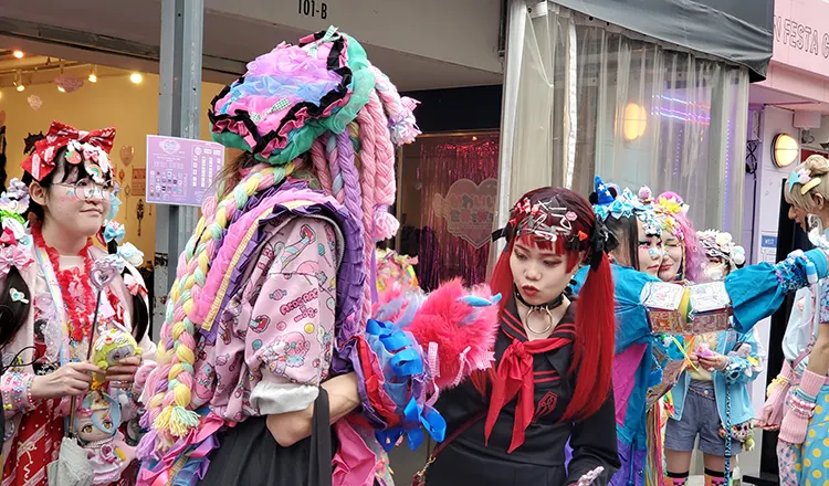 A young Japanese woman in colorful, Harajuku-style costume walking down Takeshita Street